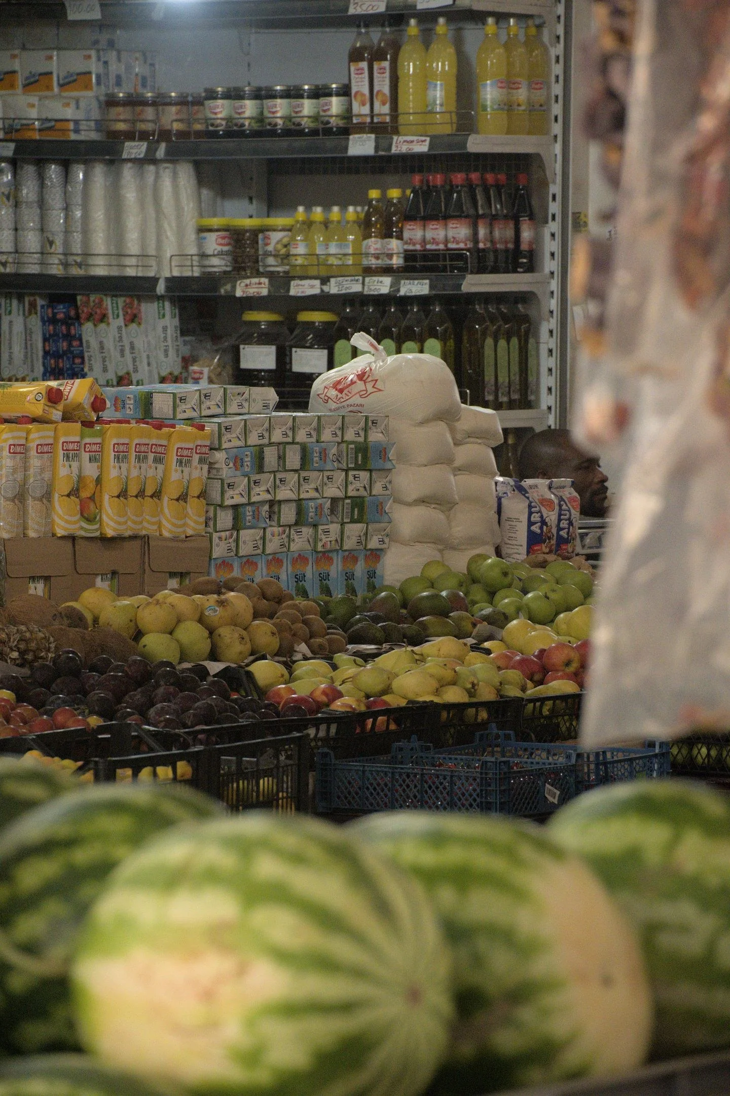 Variety of fresh fruits and products displayed in a grocery store aisle with clear copyspace.