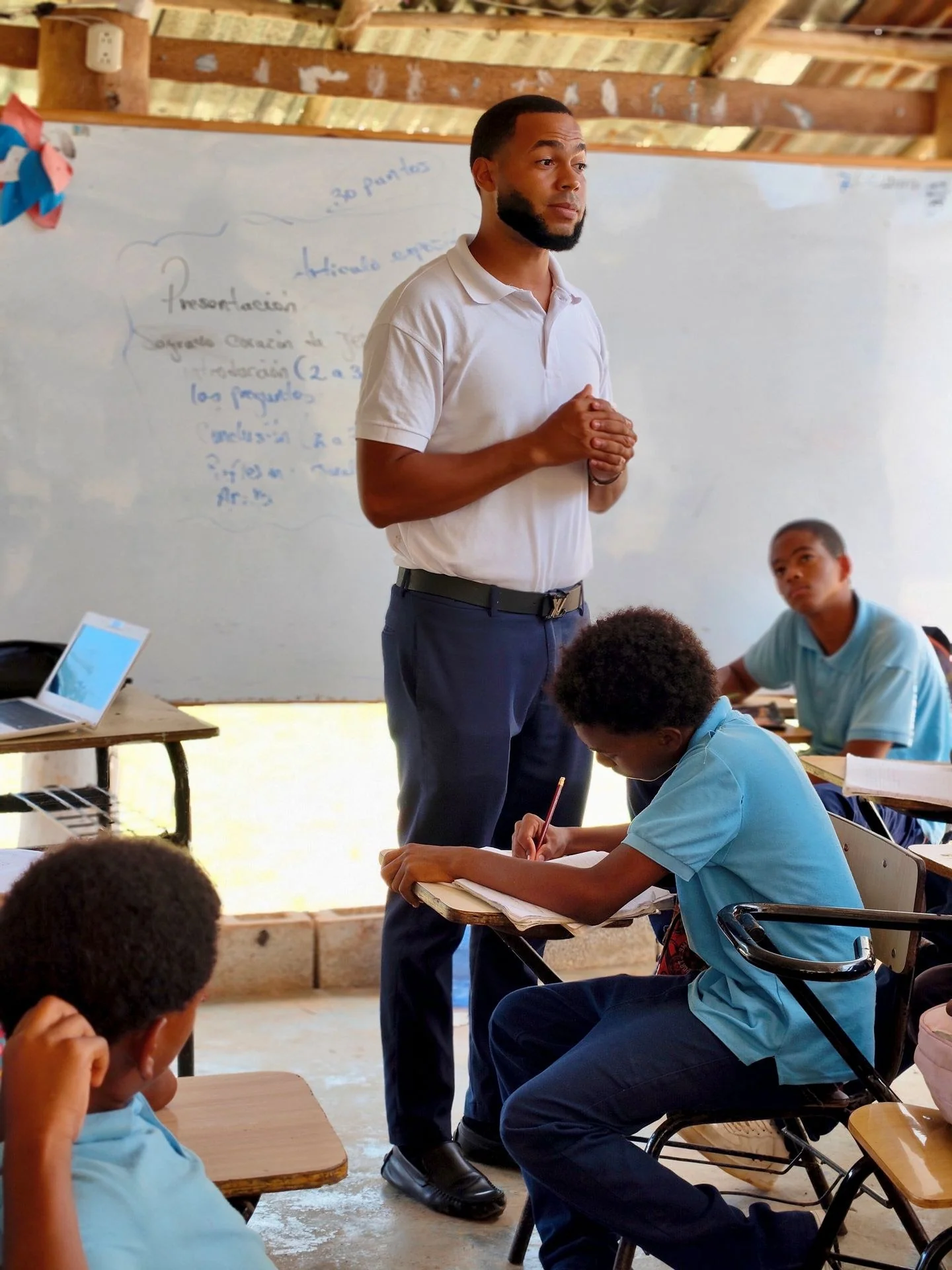 Teacher guiding students in a classroom focused on learning with engaged pupils.