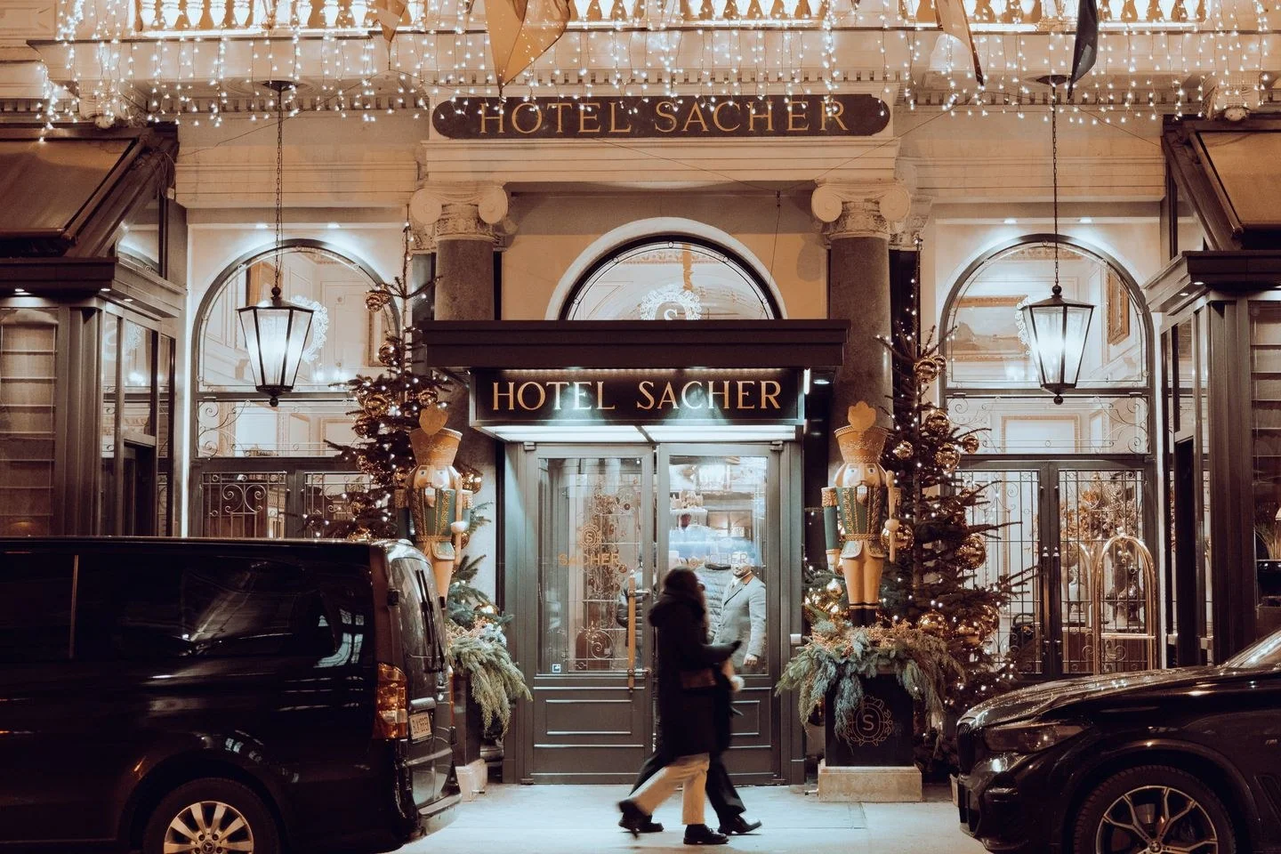 Front view of Hotel Sacher in Vienna, Austria adorned with festive Christmas lights and decorations.